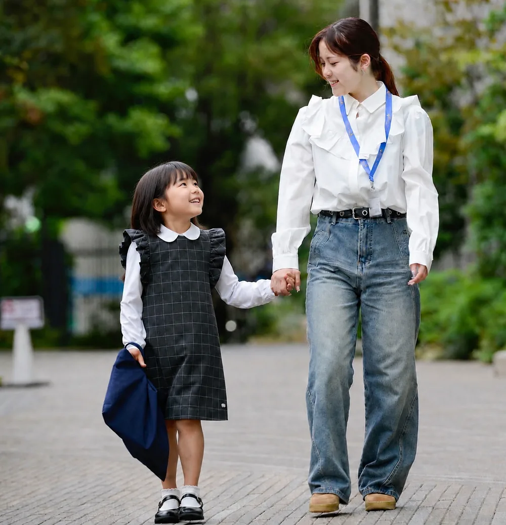 手をつなぎ、顔を見合わせて笑う子どもとBuddy