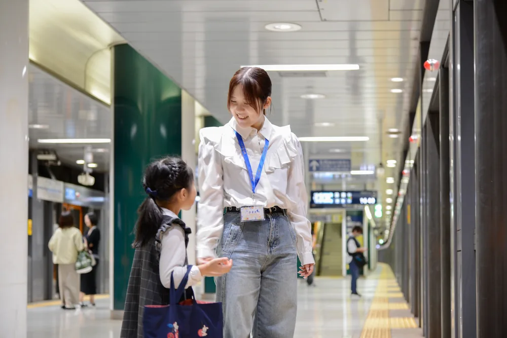 駅で子どもに笑顔で声をかけるBuddy